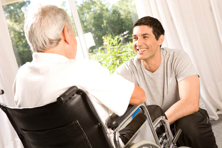 Man talking with another man in a wheelchair