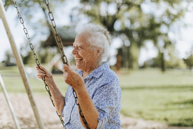 Elderly woman in a playground swing